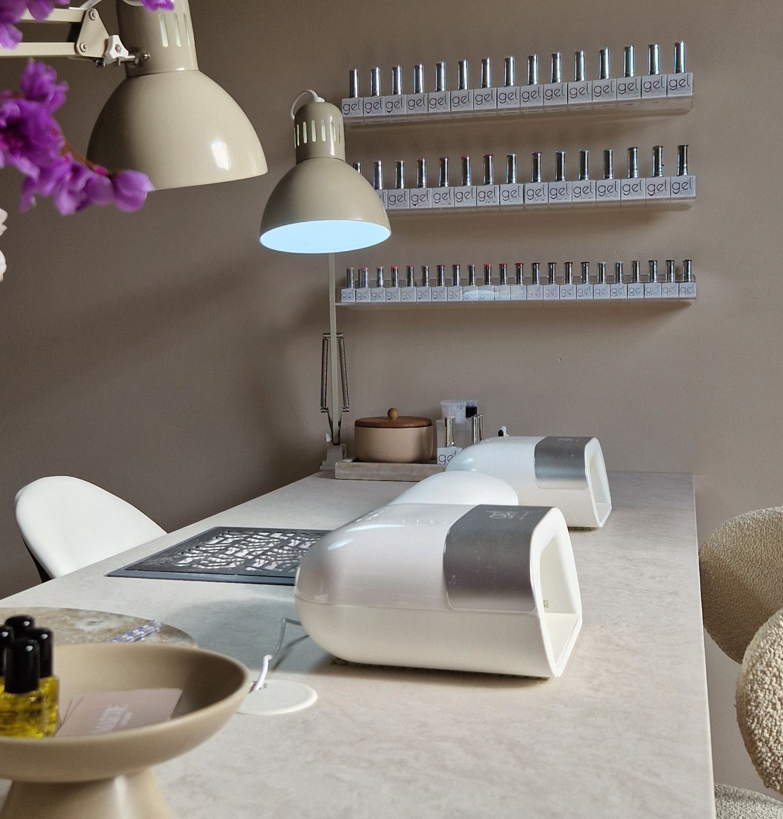 De werkplek van Martje: marmeren tafel, nagellampen en planken vol gellak